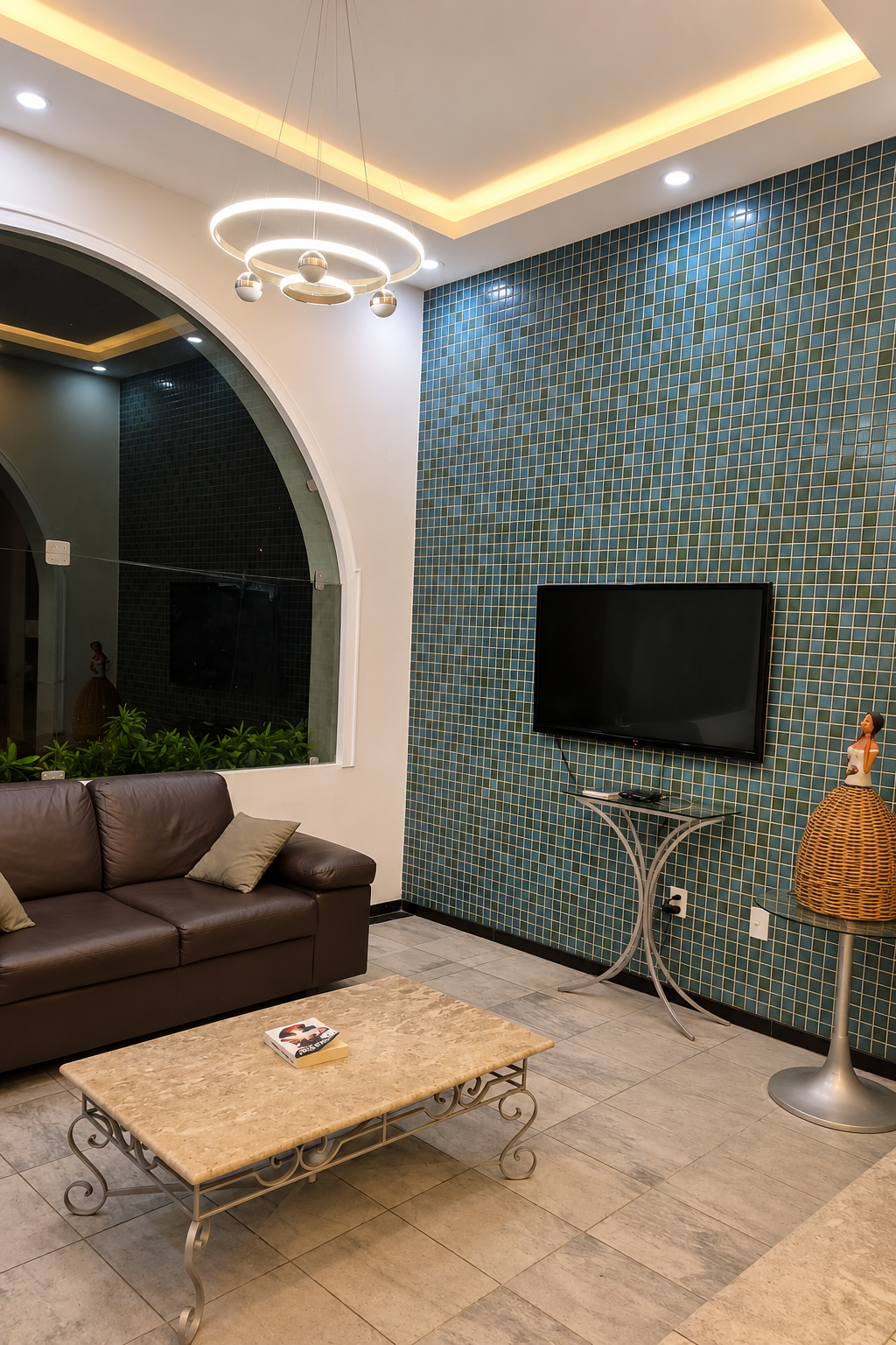 Lounge de recepção do Hotel Vitória com sofá, TV smart e iluminação acolhedora